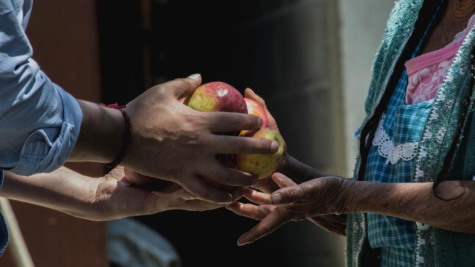 two persons holding fruits